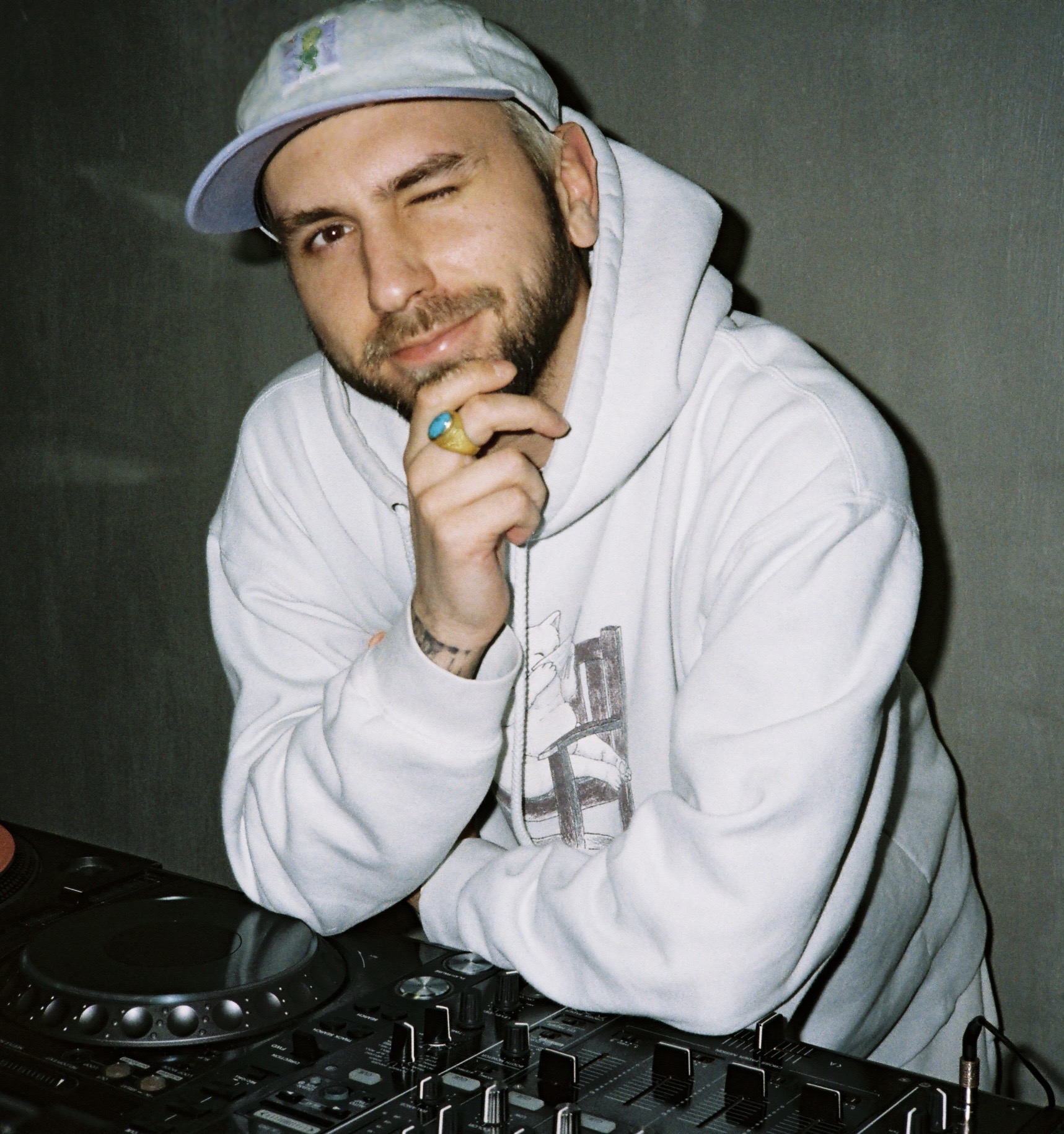 Tony Starr leaning on a DJ setup